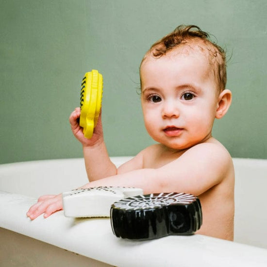 Baby in the bath playing with Etta Loves bath toys’