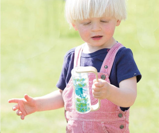Young boy outside holding Classic World rainmaker toy